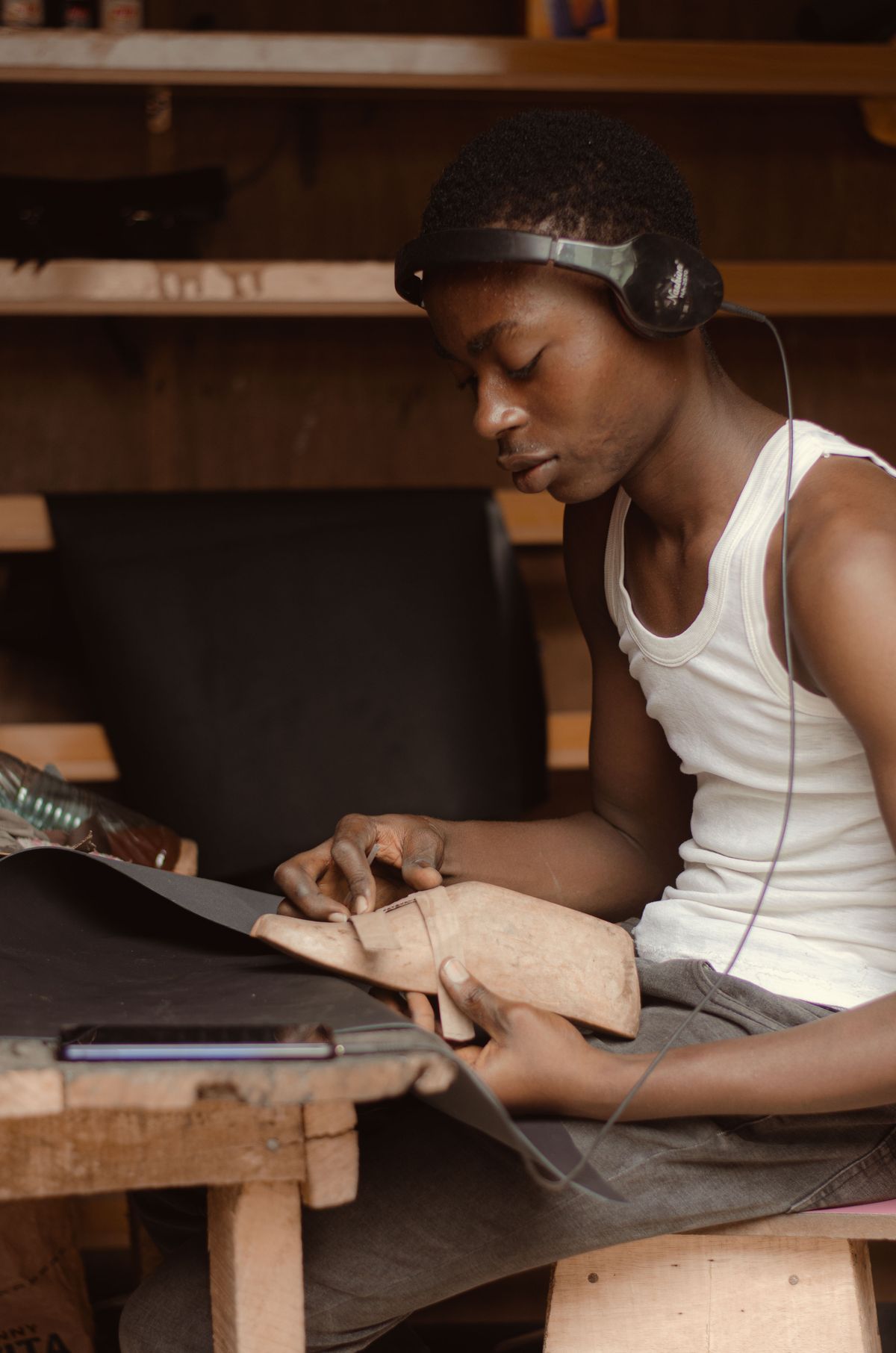 Artisan shaping leather on a wooden last